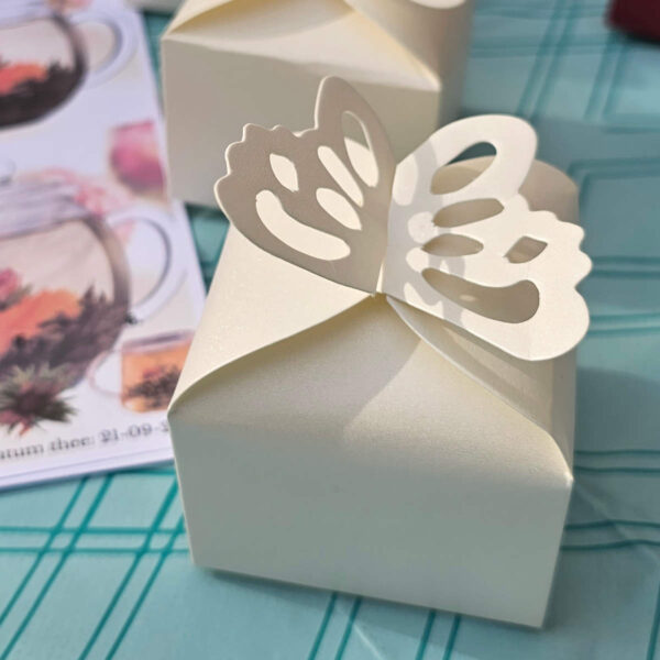 Crème doosje met theebloem met sticker met naam bruidspaar en trouwdatum